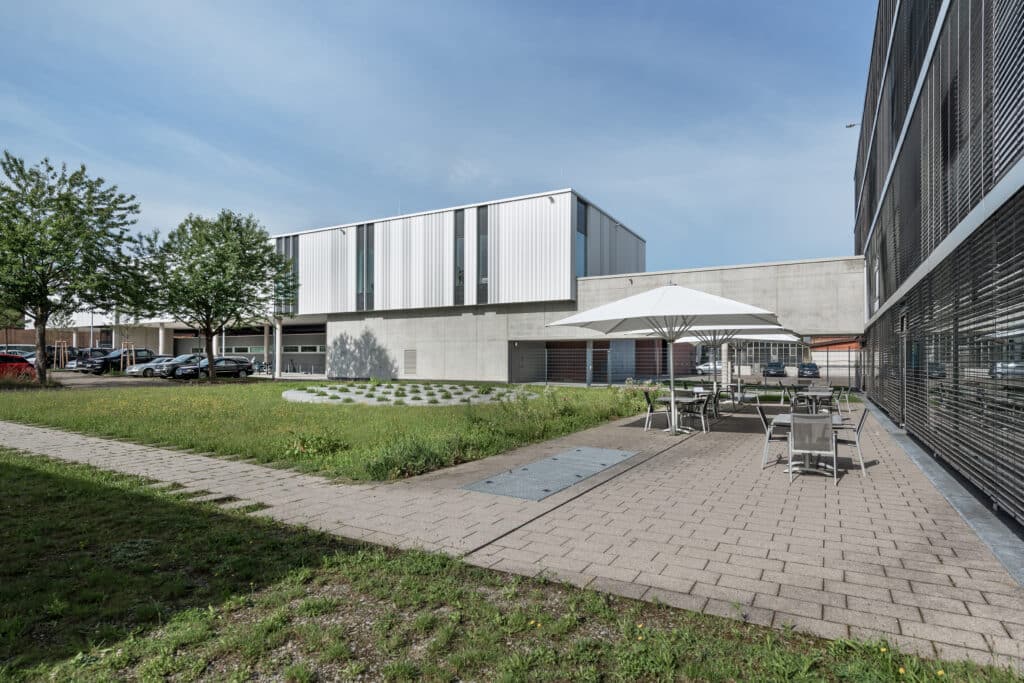 Außenansicht des Führungs- und Lagezentrums der Polizei Ludwigsburg mit Grünfläche, Terrasse und modernem Gebäudedesign.
