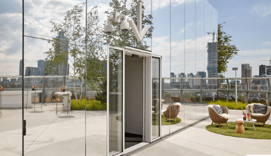 Das Schiebetürsystem Slimdrive SL fügt sich harmonisch in die Spiegelfläche der Außenfassade ein.