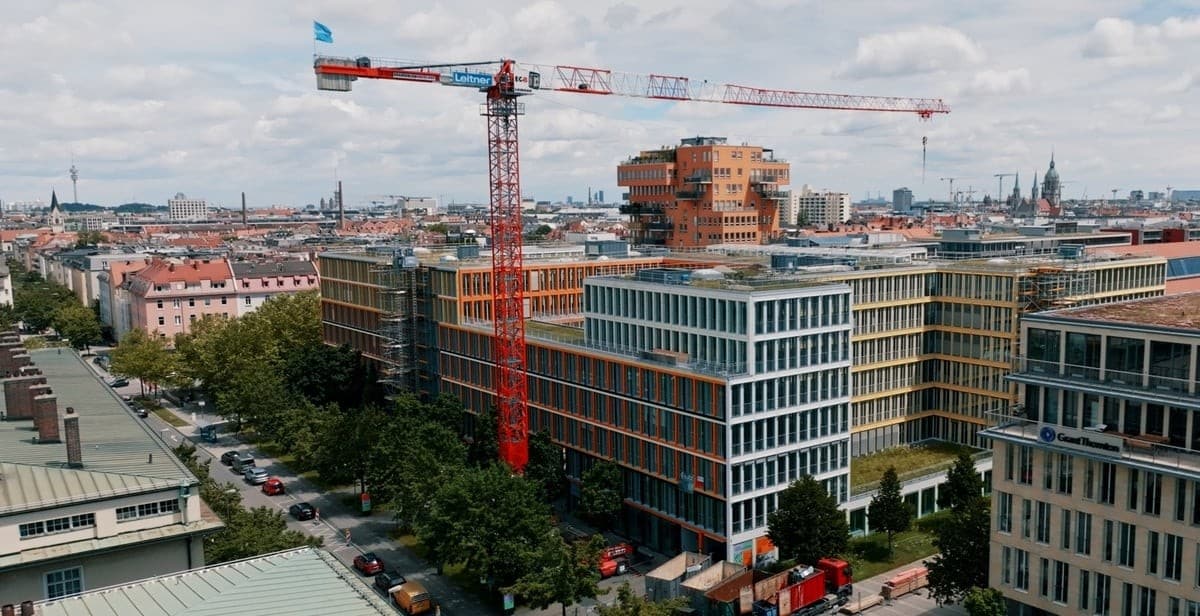 Großbaustelle mit Kran inmitten moderner Bürogebäude in München