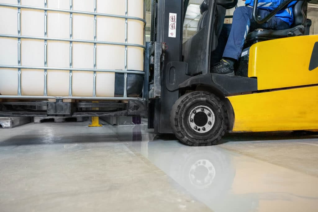 Arbeiter trägt Vergussmasse auf eine vorbereitete Fuge auf.