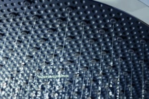 Detailansicht einer Hansgrohe Kopfbrause mit vielen feinen Wasserstrahlen, Strahldüsen aus schwarzem Kunststoff klar erkennbar.