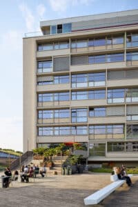 Fassade des 25hours Hotels Bikini Berlin mit Terrasse, Gästen und urbanem Flair bei Tageslicht
