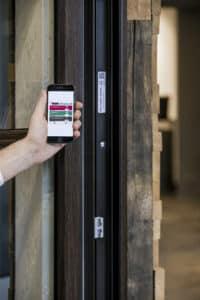 Hand hält Smartphone vor Fensterrahmen und scannt REHAU Window ID zur digitalen Identifikation und Serviceabfrage.