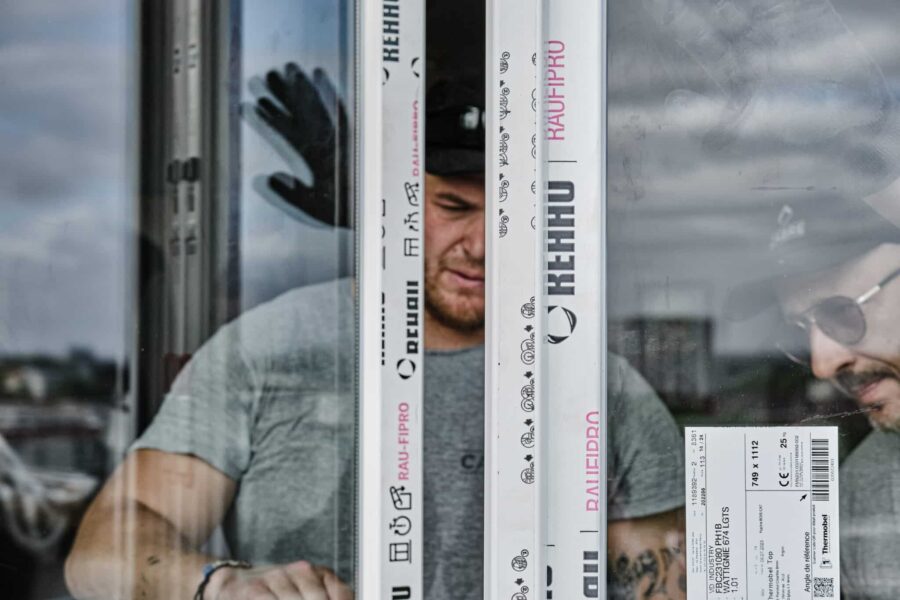 Handwerker beim Einbau eines REHAU RAU-FIPRO Fensterrahmens