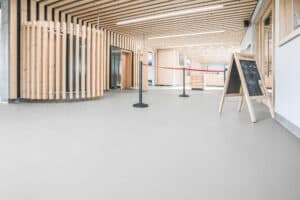 Sanierter Eingangsbereich der Tegelbergbahn in Schwangau mit hellem OS11a-Boden, Holzlamellen und moderner Empfangssituation.