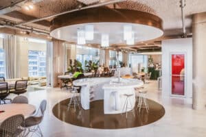 Moderne offene Arbeits- und Begegnungsfläche im Antwerp Tower mit runder Theke, Barhockern und flexiblen Arbeitsplätzen.