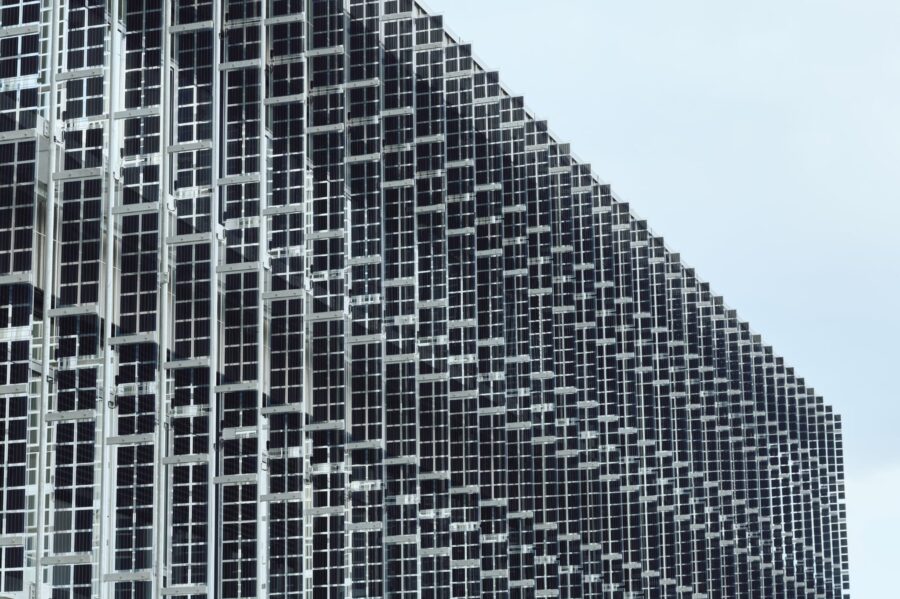 Moderne Aluminiumfassade mit geometrischer Struktur und Glasflächen eines Bürogebäudes.