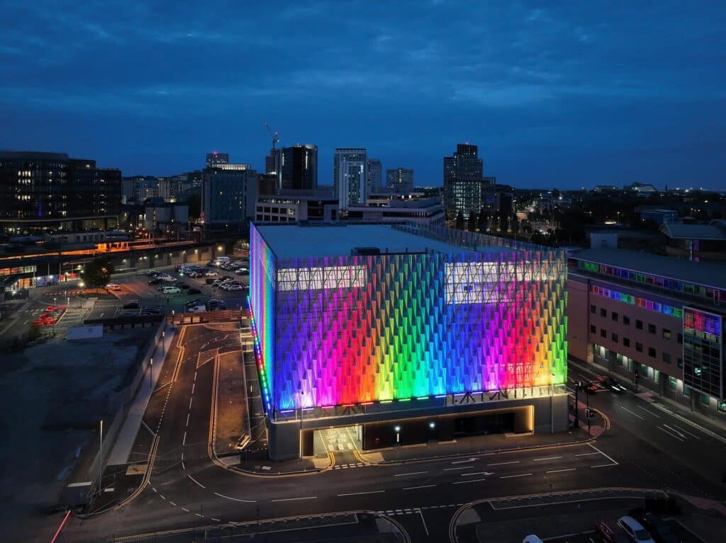 Fassade des MSCP Central Quay in Cardiff bei Nacht, beleuchtet in kräftigem Violett.