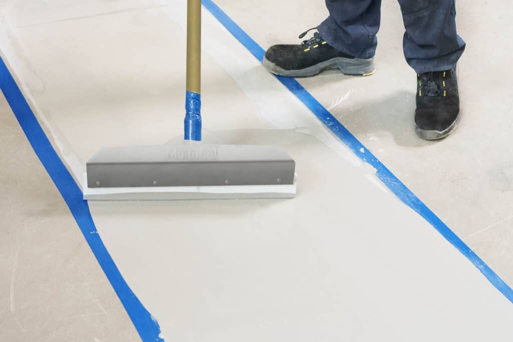 Arbeiter trägt Vergussmasse auf eine vorbereitete Fuge auf.