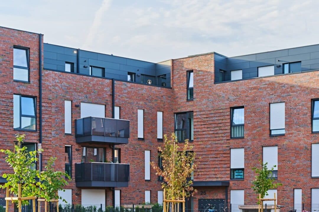Innenhof einer modernen Wohnanlage mit Klinkerfassaden und Balkonen.