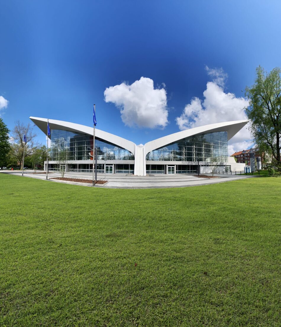 Außenansicht der Alsterschwimmhalle Hamburg mit markanter Dachkonstruktion und Glasfassade.
