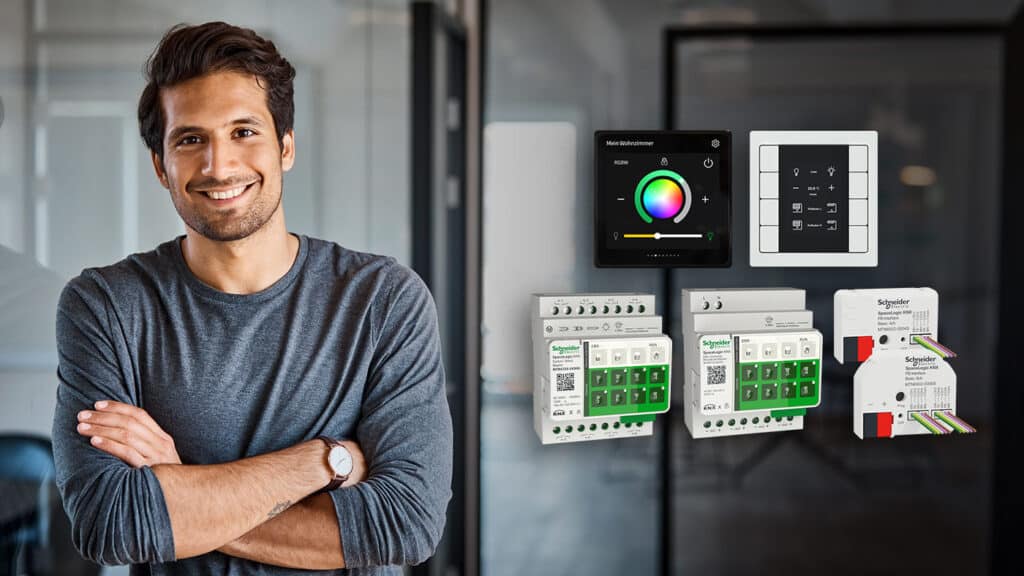 Mann steht vor KNX-Secure-Komponenten von Schneider Electric zur intelligenten Gebäudeautomation.