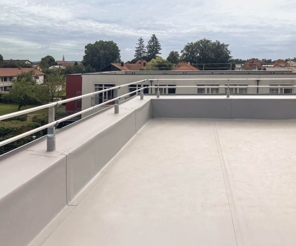 Montiertes Barrial-FIX-Kollektivschutzgeländer auf einer extensiven Flachdachanlage mit umlaufender Attika.