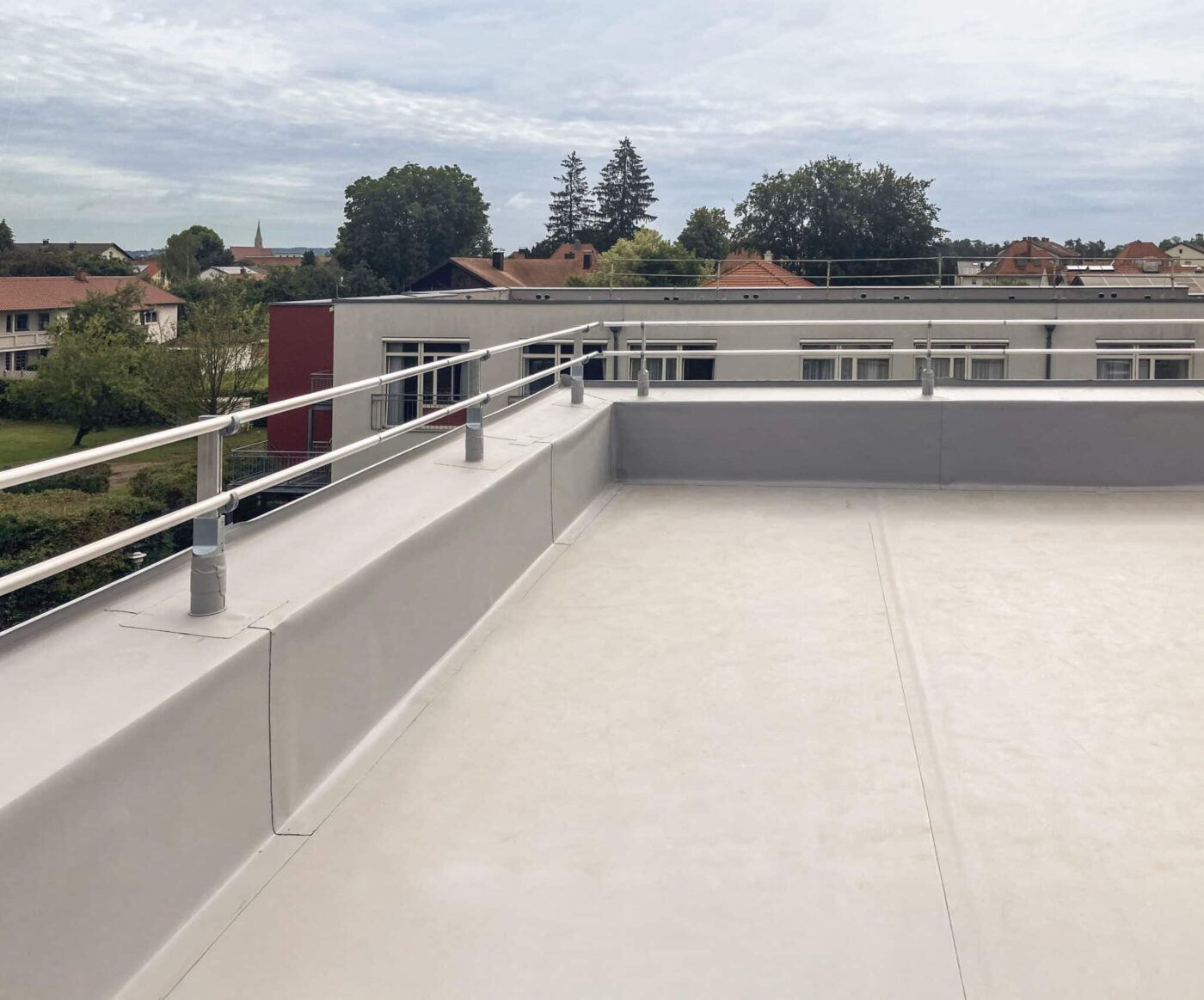 Montiertes Barrial-FIX-Kollektivschutzgeländer auf einer extensiven Flachdachanlage mit umlaufender Attika.