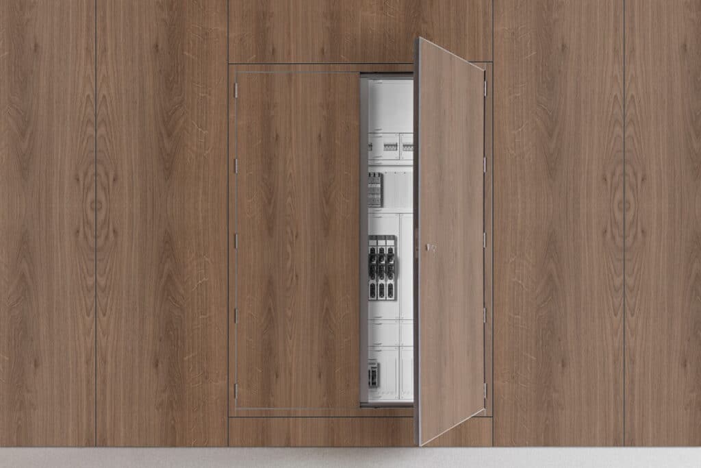 Geöffnete Revisionsklappe Priodoor RTX in Holzdekor-Optik, integriert in eine Priowall-Wand, mit sichtbarem Installationsschrank.
