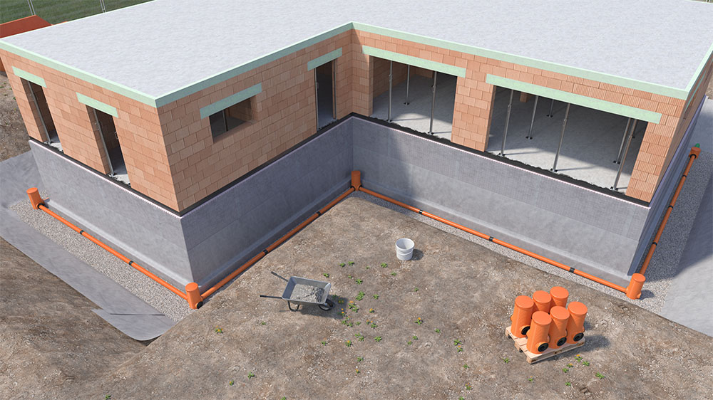 Übersicht einer Baugrube mit verlegtem Dränagesystem rund um ein Wohngebäude