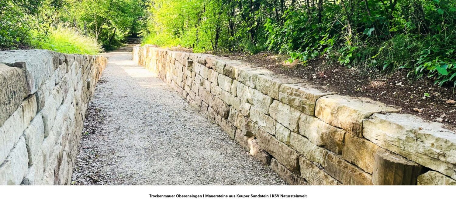 Weg flankiert von zwei Trockenmauern aus Keuper Sandstein im Grünen, umgesetzt von KSV Natursteinwelt in Oberensingen.