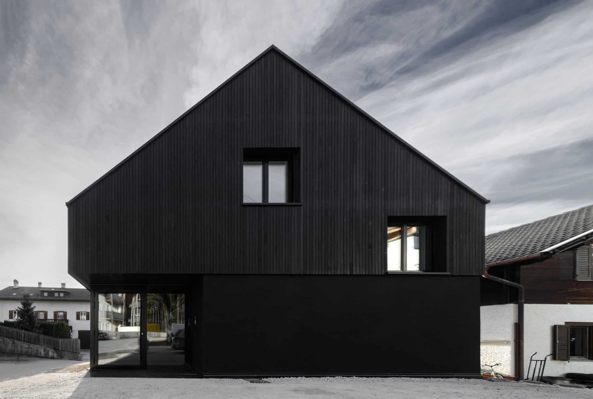 Kompakter Baukörper mit schwarzer Holzfassade und reduzierter Formensprache