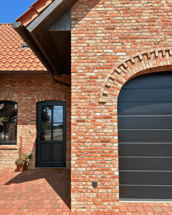 Detailansicht von Eingang und Garagentor des Einfamilienhauses mit Klinkerbögen.