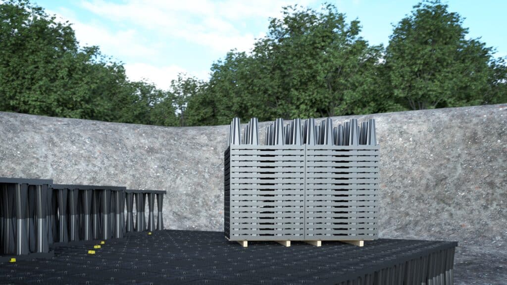 Gestapelte Rigofill ST-S Füllkörper auf einer Baugrube mit bereits verlegten Rigolenelementen im Vordergrund.