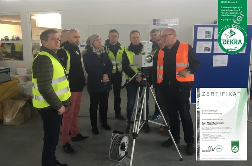Gruppe von Fachleuten in Warnwesten bei einer Schulung zur Bauschadenbewertung, ein Trainer erklärt die Anwendung eines Messgeräts, eingeblendet ist ein DEKRA-Zertifikat.