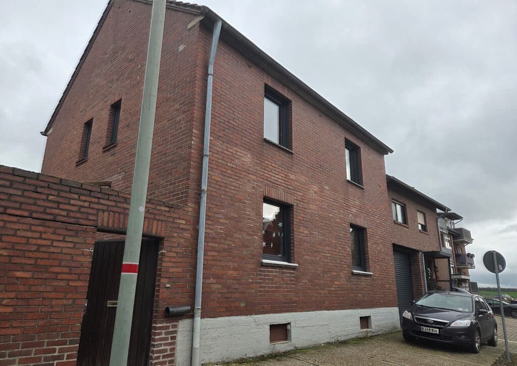 Zweistöckiges Backsteingebäude vor energetischer Sanierung – typische Bestandsfassade für den Einsatz von Insute 25-pro Einblasdämmung.