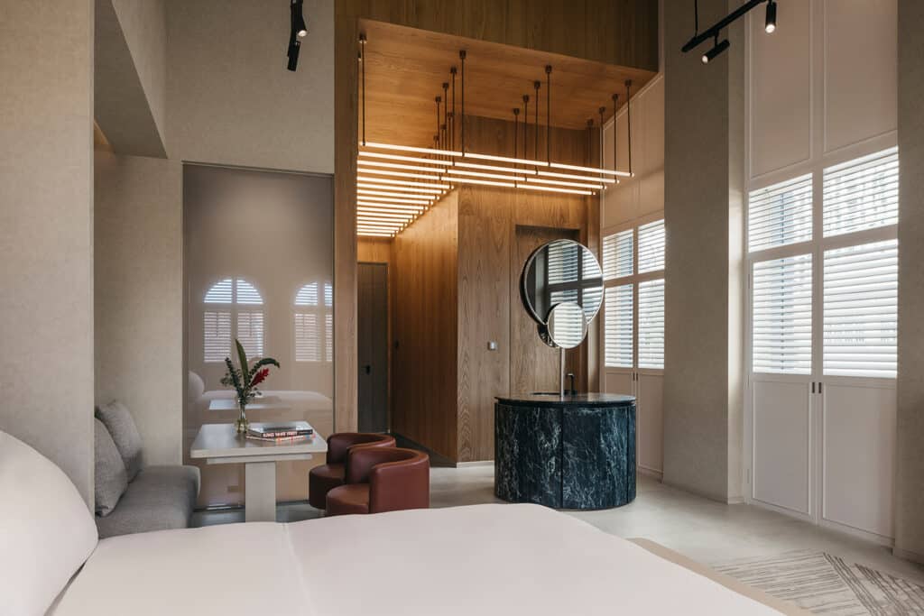 Elegantes Hotelzimmer mit offener Raumgestaltung, Designmöbeln und smarter KNX Technik.