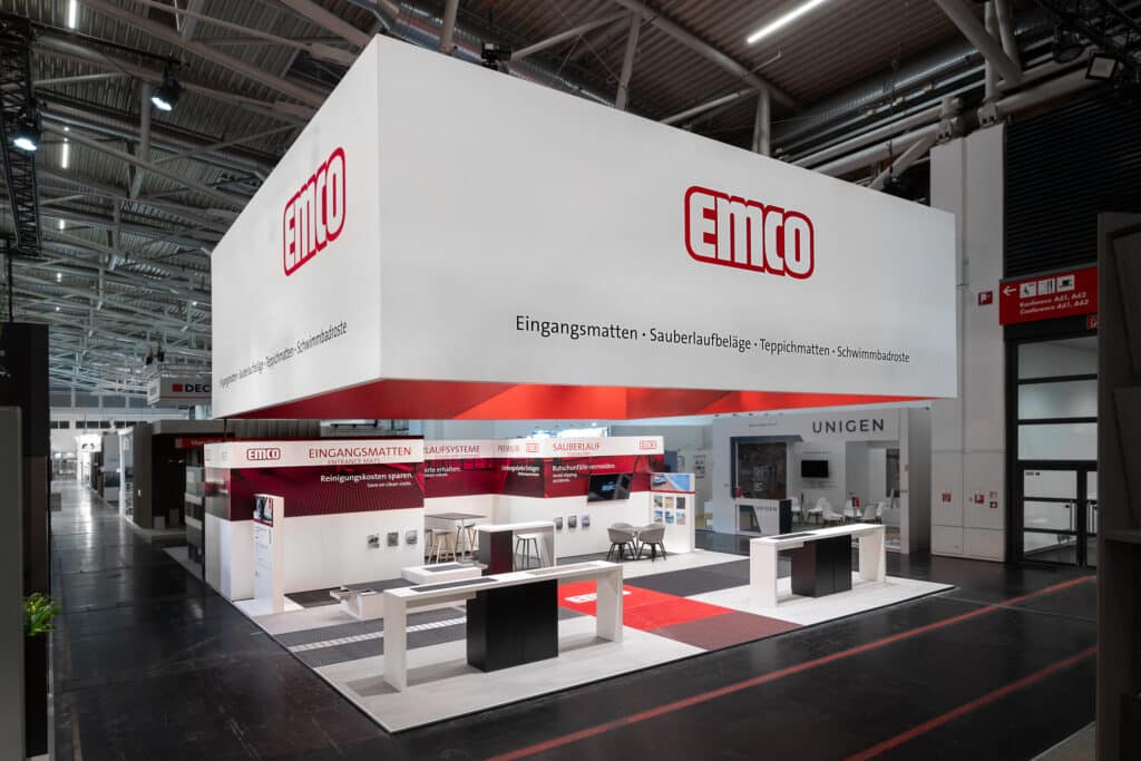 Moderner EMCO-Messestand auf einer Fachmesse, präsentiert Eingangsmatten, Sauberlaufsysteme und weitere Produkte.