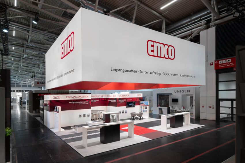 Moderner EMCO-Messestand auf einer Fachmesse, präsentiert Eingangsmatten, Sauberlaufsysteme und weitere Produkte.