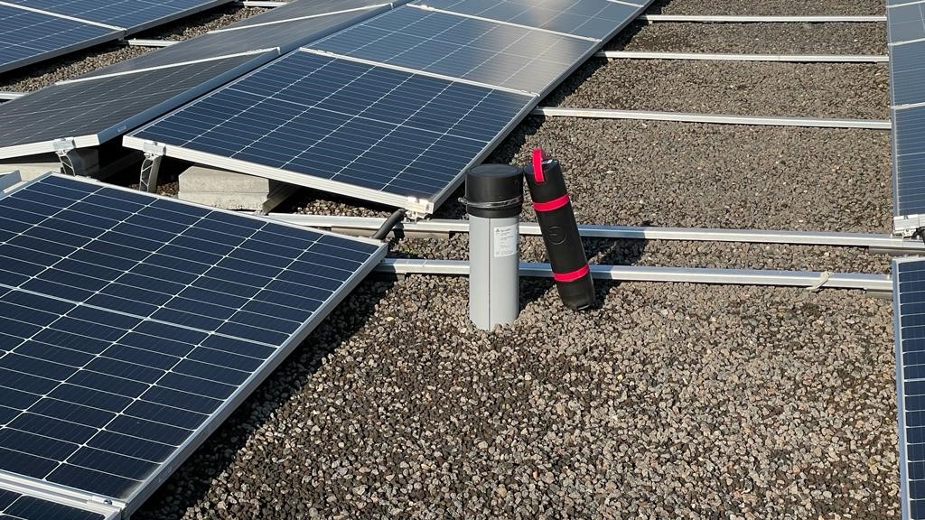 Installierte Monitoring-Sensoren auf einem Flachdach mit Photovoltaik-Modulen zur Überwachung von Dichtheit und Feuchtigkeit.