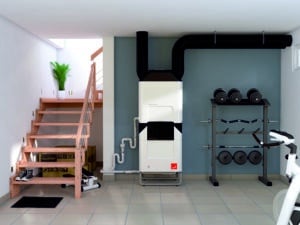 Heiz- und Kühleinheit Zehnder ComfoClime Cool in einem hellen Kellerraum mit Trainingsbereich und offenem Treppenaufgang.