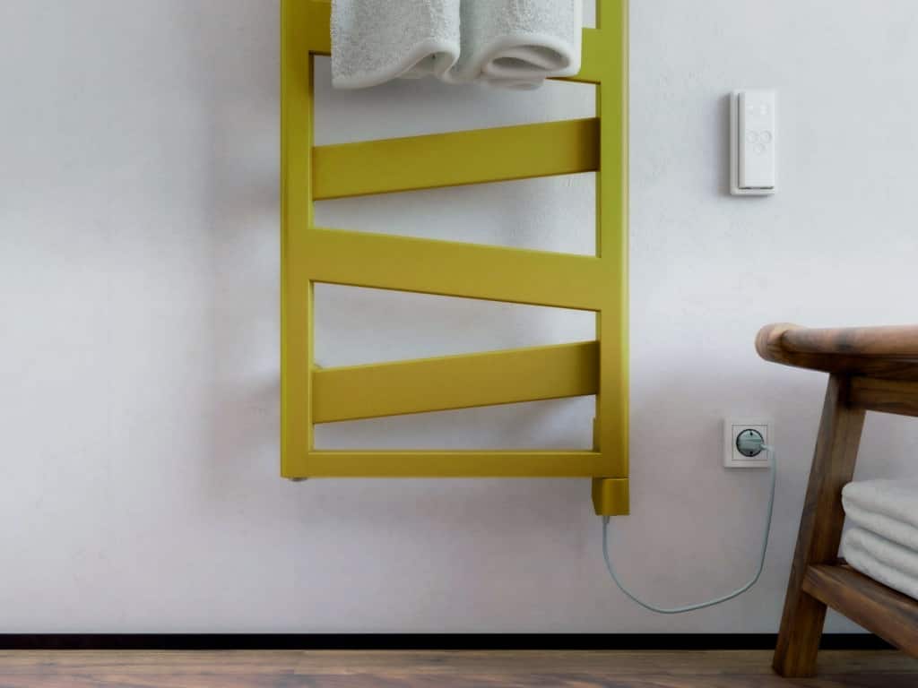 Moderner gelber Heizkörper von zehnder mit IHD Heizstab in einerm Badezimmer macht die Technik am Heizkörper nahezu unsichtbar