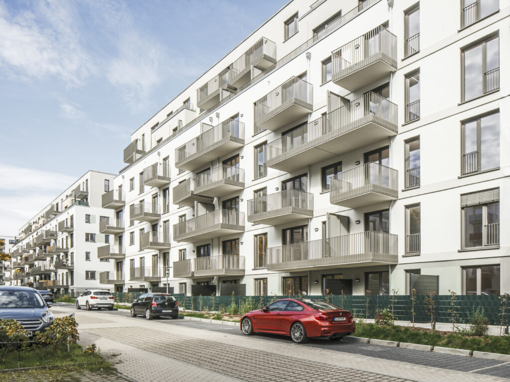 Straßenansicht der Wohnanlage PP49 mit rhythmisch angeordneten Balkonen und klarer Fassadengliederung.