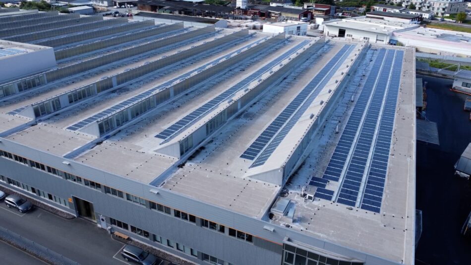 Großflächige Solaranlage auf dem Dach eines Industriegebäudes in Menden, aufgenommen aus der Vogelperspektive.