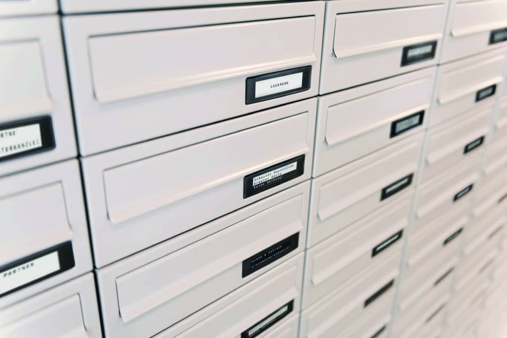 Weiße Briefkastenanlage mit Namensschildern in einem modernen Wohngebäude