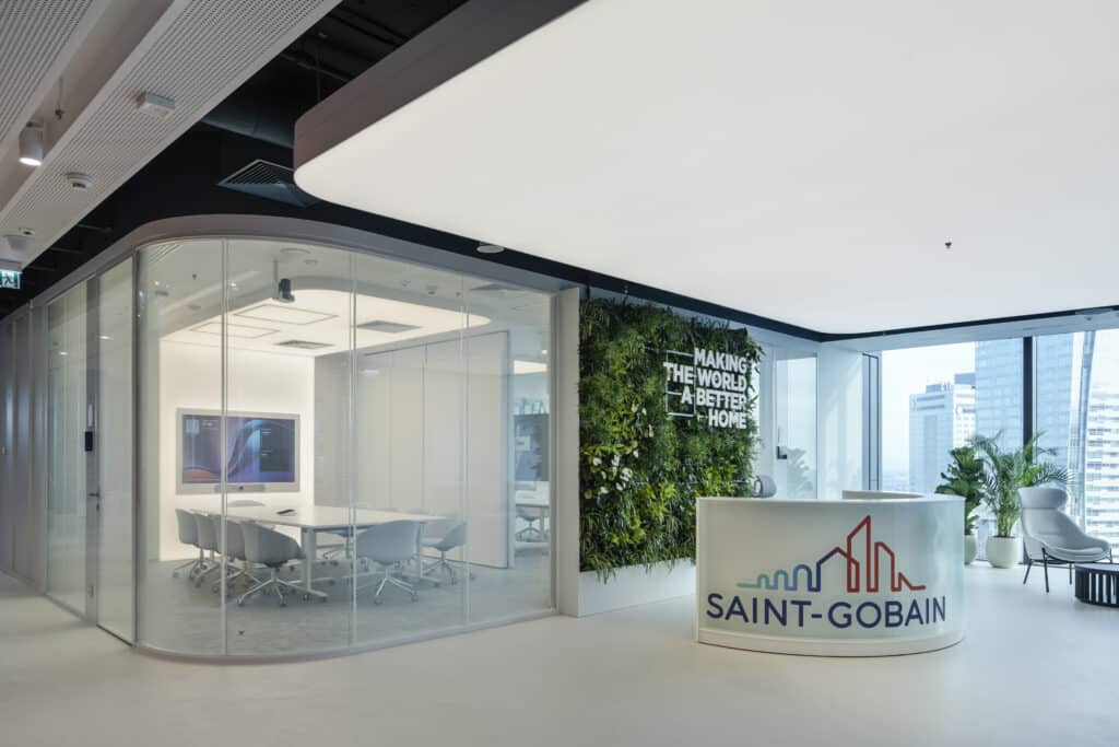 Moderner Empfangsbereich von Saint-Gobain mit Glaswänden und begrüntem Wandpanel