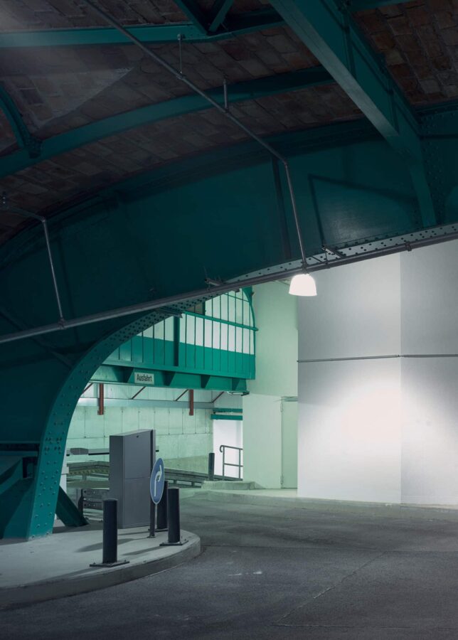 Historisches Backsteingewölbe mit grüner Stahlkonstruktion und Lüftungstechnik in modernisierter Parkebene.