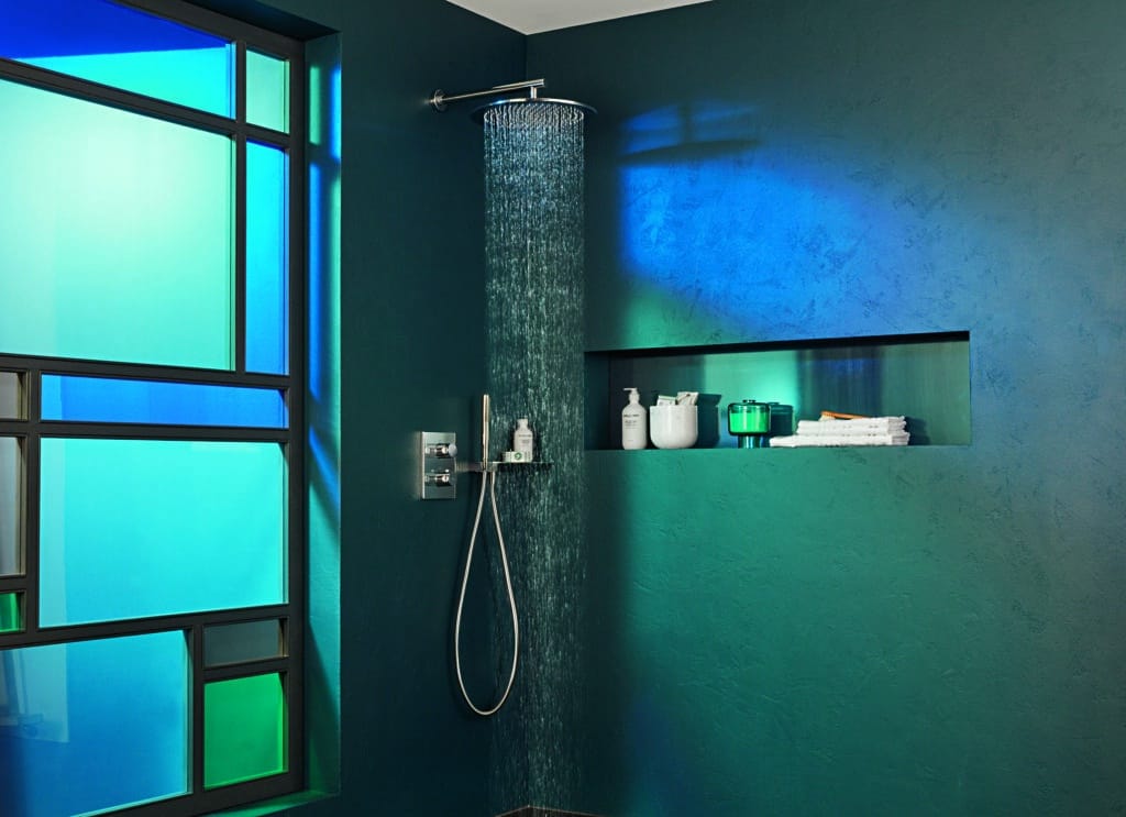 Offene Regendusche in einem dunkelgrünen Badezimmer mit farbig beleuchtetem Glasfenster und integrierter Ablagenische.
