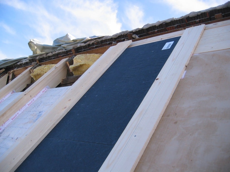 Vakuum-Isolationspaneel (VIP) in ein Dach zwischen Holzsparren eingelegt; das Paneel sitzt passgenau und dient als zusätzliche Außendämmung unter der späteren Dachdeckung.