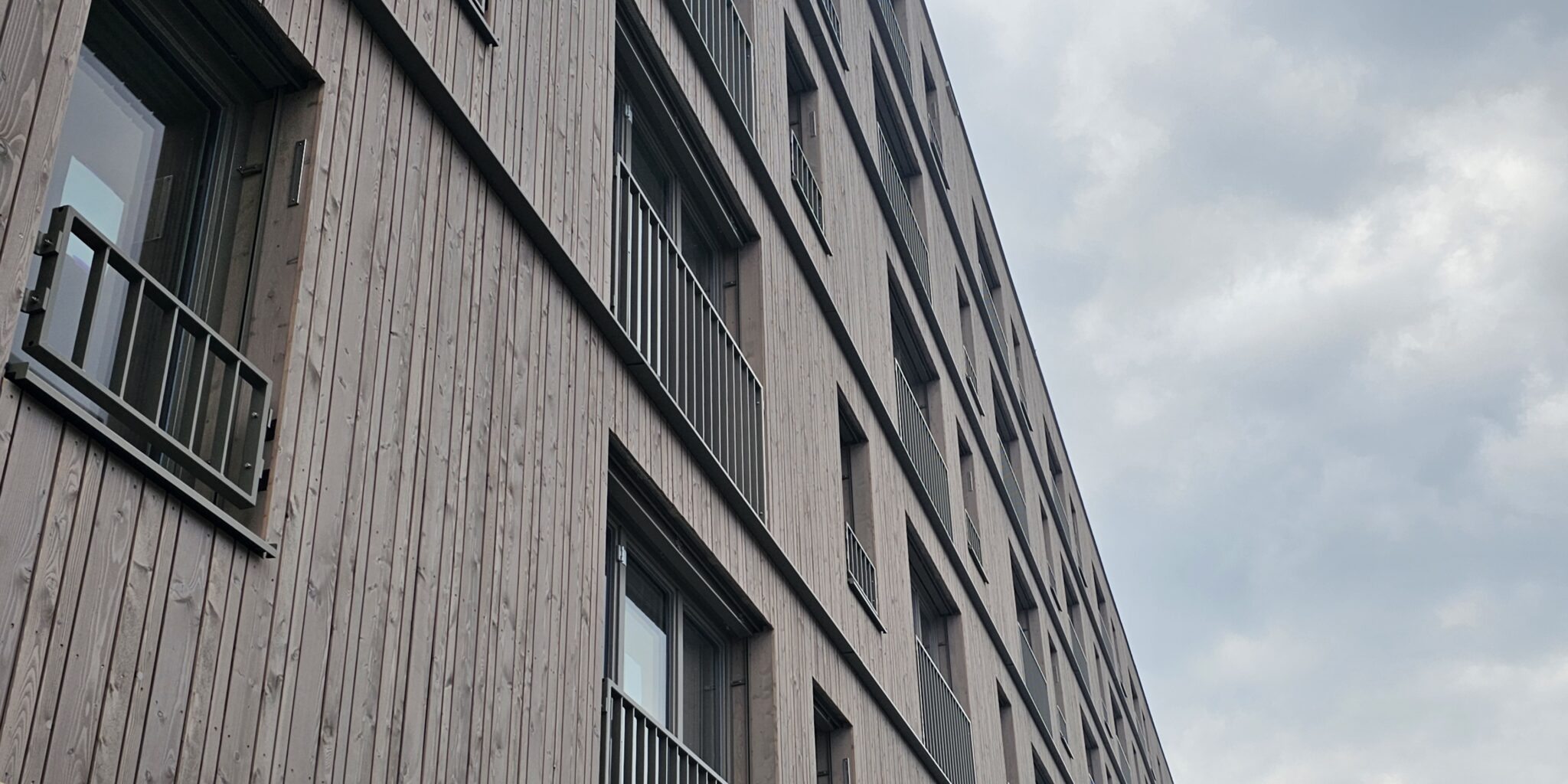 Mehrgeschossige Holzfassade mit verbauten Z-Protect Profilen als wettergeschützter Fenster- und Fassadenanschluss.