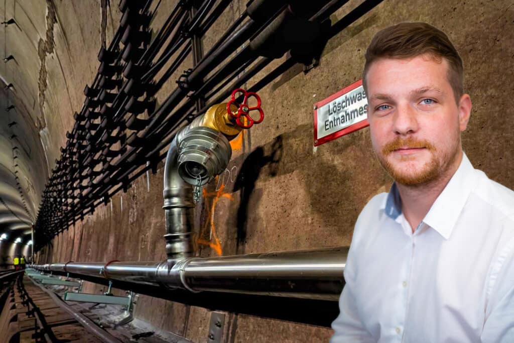 Edelstahl-Löschwasserleitung in einem Tunnel mit Entnahmestelle und Porträt eines Fachplaners im Vordergrund.
