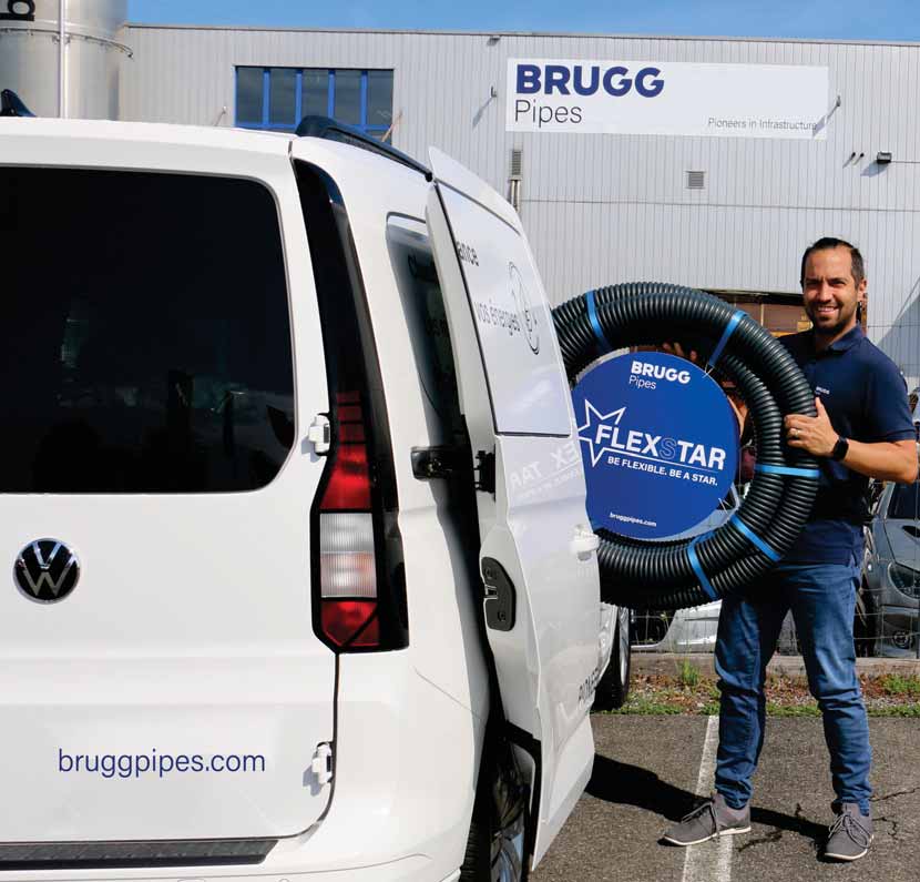 Mitarbeiter vor BRUGG Pipes Gebäude mit FLEXSTAR Rohrsystem.