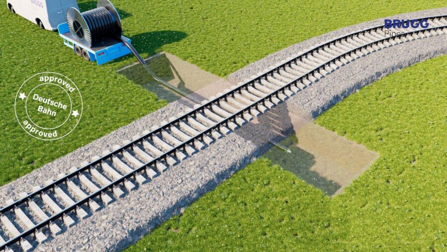 Darstellung eines unterirdischen Schutzrohrsystems von BRUGG Pipes für die sichere Querung von Leitungen unter Bahngleisen, inklusive Kabeltrommel und Einzugsfahrzeug; mit Kennzeichnung „Deutsche Bahn approved“