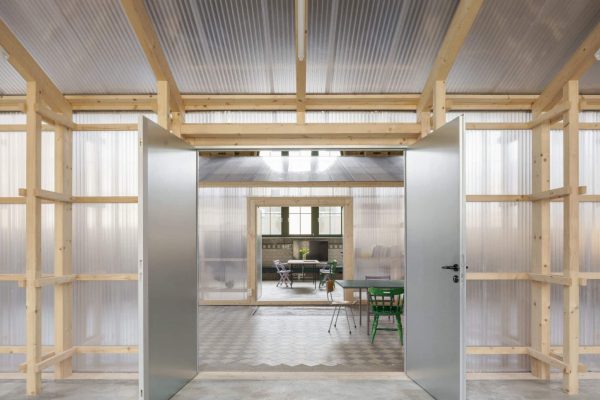 Offene Begegnungsfläche in der Halle Leipzig mit moderner Holzkonstruktion und lichtdurchlässigen Wänden.