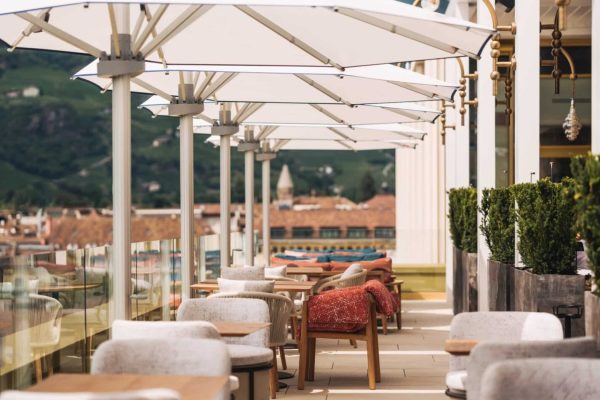 Weiße PALAZZO Noblesse Großschirme auf der Terrasse des Falkensteiner Hotels und MOCHI Restaurants in Bozen.