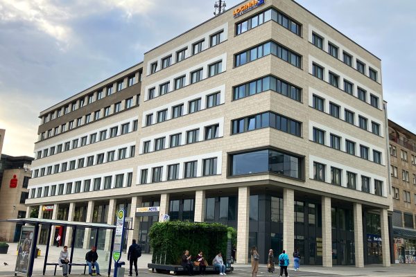 Modernes City Center Neuzustand nach der Sanierung mit heller Steinfassade, Loginn Hotel und dm-Markt.