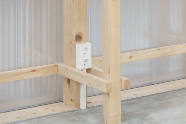 Weiße LS CUBE von JUNG Doppelsteckdose an einem Holzbalken für flexible Leitungsführung ohne Wandeingriff.