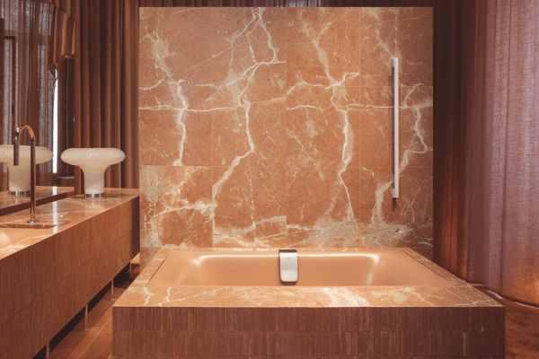 Casa Decor 2026 - Space Kaldewei by ILV Isabel López Vilalta: Pfirsichfarbene Marmor-Badewanne und warme Vorhänge.