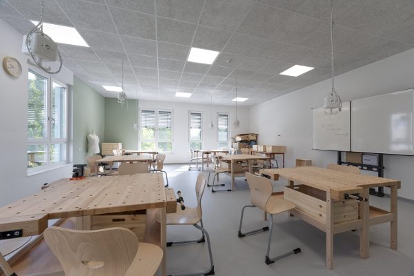 Helle Fachklassenräume der Grundschule Angermünde mit hölzernen Werkbänken, Farbakzenten und großen Fenstern.