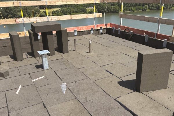 Fachgerechte Verlegung von FOAMGLAS® T3+ Dämmplatten auf einem Flachdach mit weitem Flusspanorama im Hintergrund.